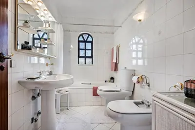 a white bathroom with a sink and a toilet at Íris by Algarve Villa Holidays in Galé