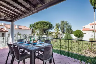 a table and chairs on a patio with a fence at Íris by Algarve Villa Holidays in Galé