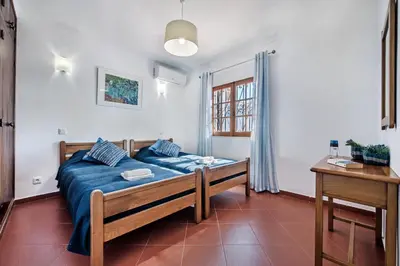 a bedroom with a blue bed in a room at Íris by Algarve Villa Holidays in Galé