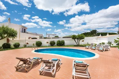 a villa with a swimming pool and lounge chairs at Isabel by Algarve Villa Holidays in Galé