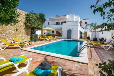 a swimming pool with chairs and a house at Rebela by Algarve Villa Holidays in Galé