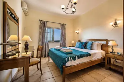 a bedroom with a bed and a desk and a mirror at Rebela by Algarve Villa Holidays in Galé