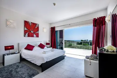 a bedroom with a bed and a large window at Vista Mar by Algarve Villa Holidays in Sesmarias
