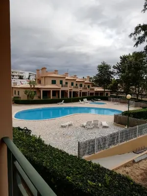 a swimming pool with lounge chairs in front of a building at Villa V2 C in Albufeira