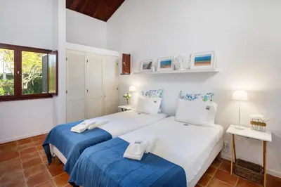 two beds in a room with white and blue at Pura Vida Falésia by The Portuguese Butler in Albufeira