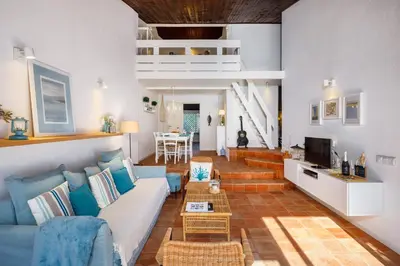 a living room with a blue couch and a table at Pura Vida Falésia by The Portuguese Butler in Albufeira