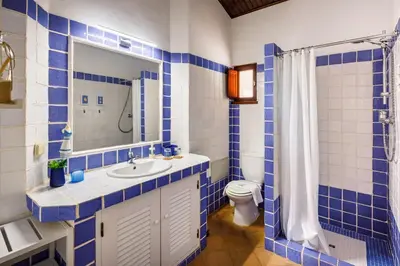 a blue and white bathroom with a sink and a toilet at Pura Vida Falésia by The Portuguese Butler in Albufeira