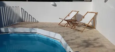 a patio with a chair and a swimming pool at Pura Vida Falésia by The Portuguese Butler in Albufeira