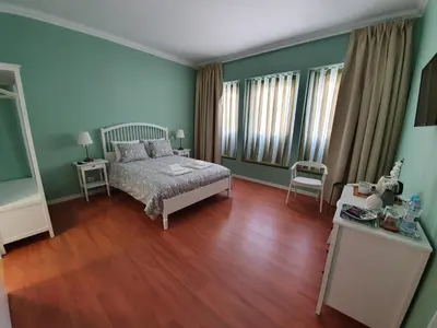 a bedroom with green walls and a bed and wooden floors at Inn Faro - Casa Amarela - Guest House in Faro