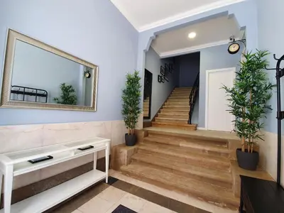 a hallway with stairs and a mirror and potted plants at Inn Faro - Casa Amarela - Guest House in Faro