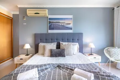 a bedroom with a large bed with a blue wall at Vila da Encosta - Private - Heated swimming pool - By bedzy in Albufeira