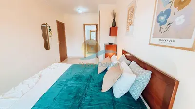 a bedroom with a bed with a green comforter and pillows at Monte da Balaia Prime by Sunny Deluxe in Albufeira