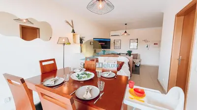 a dining room and living room with a dining table at Monte da Balaia Prime by Sunny Deluxe in Albufeira