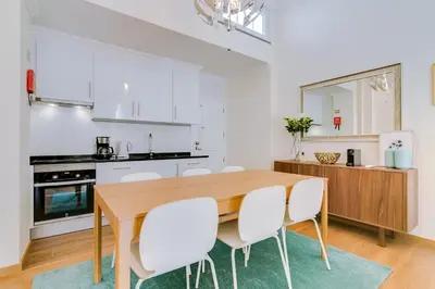 a kitchen and dining room with a wooden table and white chairs at Casa Azul Traditional House - Faro in Faro