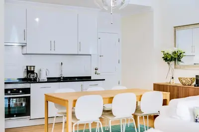 a kitchen and dining room with a wooden table and white chairs at Casa Azul Traditional House - Faro in Faro