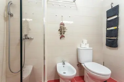 a bathroom with a toilet and a glass shower at Magic Theatre Faro Center in Faro