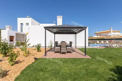 a gazebo with a table and chairs in a yard at Villa Alfazema - heatable pool in Albufeira