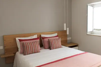 a bedroom with a bed with red and white pillows at Cardeal Suites & Apartments in Faro