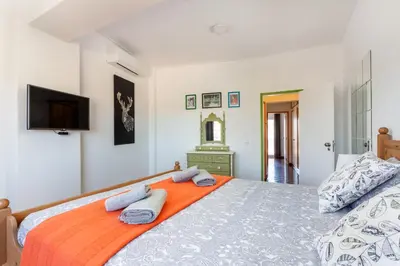 a bedroom with a large bed with towels on it at Dreamers Duplex with Seaview in Faro