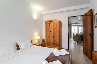 a bedroom with a large bed and a living room at Hopstays Vilamoura All In - Marina View Apartment in Vilamoura