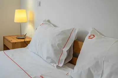 two beds with towels on them in a bedroom at Hopstays Vilamoura All In - Marina View Apartment in Vilamoura