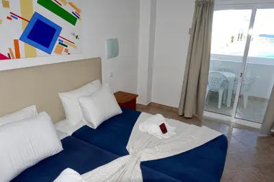 a bedroom with a bed with a blue blanket and white pillows at Oura Ocean Front in Albufeira