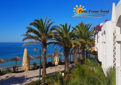 a view of a resort with palm trees and the ocean at Oura Ocean Front in Albufeira