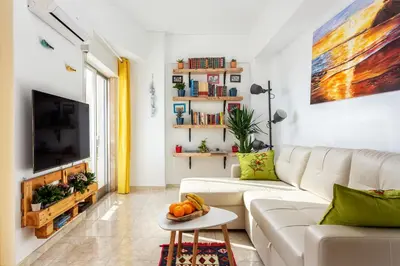 a living room with a white couch and a tv at Skyline Blue Dream in Faro