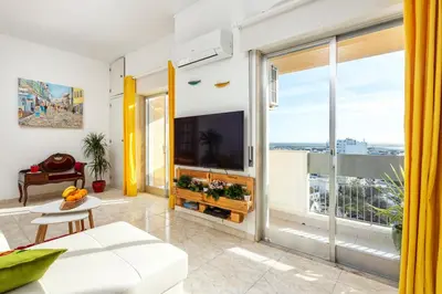 a living room with a tv and a large window at Skyline Blue Dream in Faro