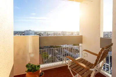 a balcony with a chair and a view of a city at Skyline Blue Dream in Faro