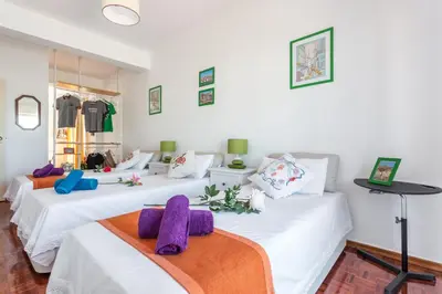 a room with three white beds with purple pillows at Sea View Fairy Tale in Faro