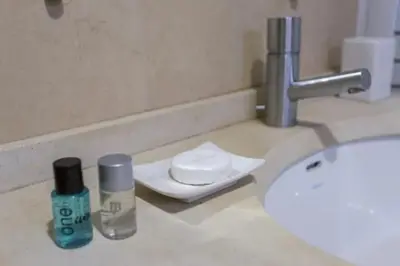 a bathroom sink with two bottles ofodorizers on a counter at Apartamento sobre a praia in Olhos de Água