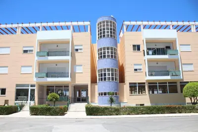 an apartment building with a water tower at Vilamoura, Marina Sol T1 in Quarteira