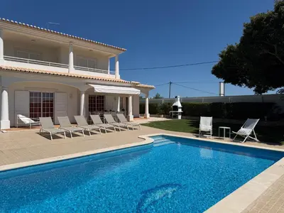 a villa with a swimming pool in front of a house at Casa Alves - Villa with private heated swimming pool in Olhos de Água