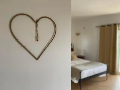 a heart hanging on a wall next to a bedroom at Casa Alves - Villa with private heated swimming pool in Olhos de Água