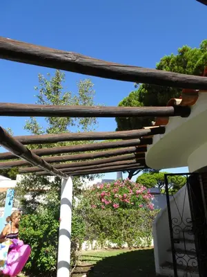 a woman is sitting on a pergola at Vilamoura Fantástica Moradia com Piscina Privada in Vilamoura