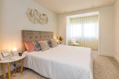 a living room with a white couch and a tv at Quarteira Beach Stunning Apartment in Quarteira
