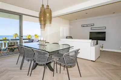 a balcony with a table and chairs and the ocean at Quarteira Beach Stunning Apartment in Quarteira