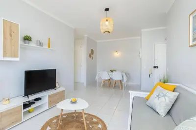 a living room with a couch and a tv at Centralgarve - 1 Bedroom Apartment Near the Beach in Quarteira - Anglo Atlântico in Quarteira
