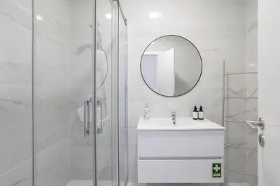 a white bathroom with a sink and a mirror at Centralgarve - 1 Bedroom Apartment Near the Beach in Quarteira - Anglo Atlântico in Quarteira