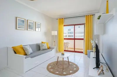 a living room with a couch and a tv at Centralgarve - 1 Bedroom Apartment Near the Beach in Quarteira - Anglo Atlântico in Quarteira