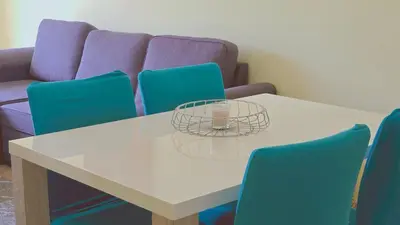 a table with blue chairs and a glass bowl on it at Praia Eulália with pool and 5 minutes from the beach in Albufeira