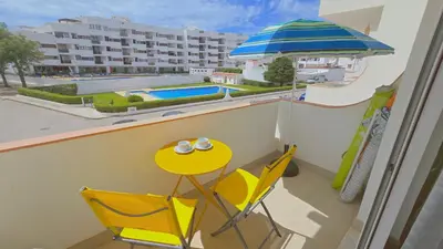 a balcony with a table and chairs and a pool at Praia Eulália with pool and 5 minutes from the beach in Albufeira