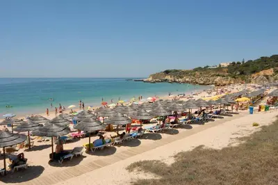 a beach with many umbrellas and a crowd of people at Villa White Sands - Private Oasis, Heated Pool, Beaches & Strip Nearby in Albufeira