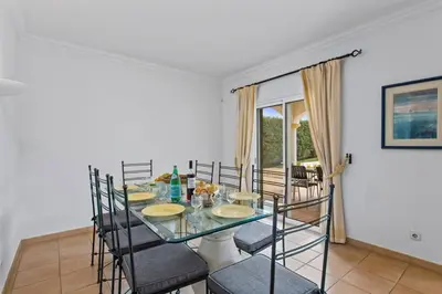 a dining room with a glass table and chairs at Villa White Sands - Private Oasis, Heated Pool, Beaches & Strip Nearby in Albufeira