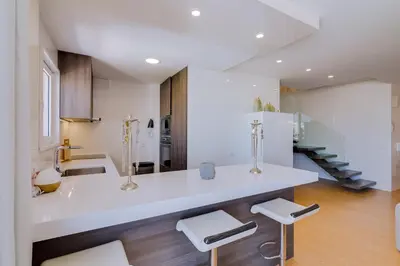a kitchen with a white counter and two stools at Gold Suites - Luxurious apartment - Sea view in Vilamoura