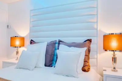 a bedroom with a white bed with two lamps at Gold Suites - Luxurious apartment - Sea view in Vilamoura