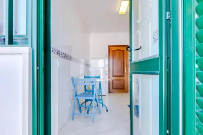a kitchen with blue chairs and a table at Mango Apartment - Faro city center in Faro
