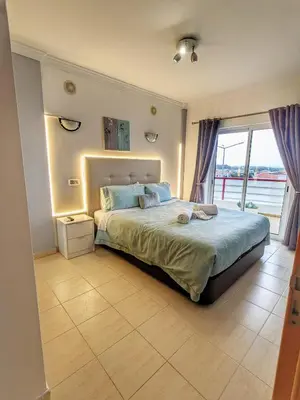 a living room with a tv and a table at Penthouse with Private Rooftop & Seaview in Guia