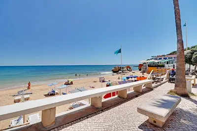 a beach with a white bench and the ocean at Albufeira Beach 1 by Homing in Albufeira